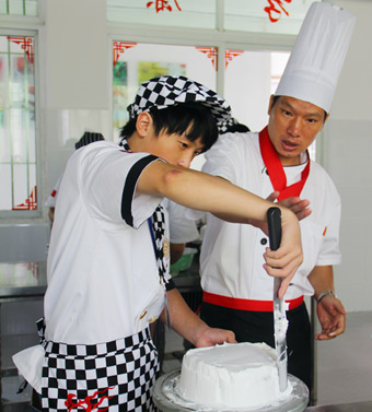 在老师的指导下抹胚 福建新东方烹饪学校【新生访谈】黄峰:15岁少年的西点烘焙梦